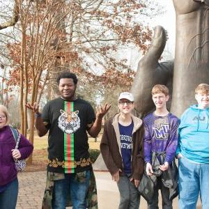 Members of the Falcon Flight program in front of the Becoming statue on the UM campus.